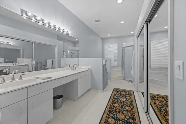 a spacious bathroom with a double vanity sink a mirror and shower