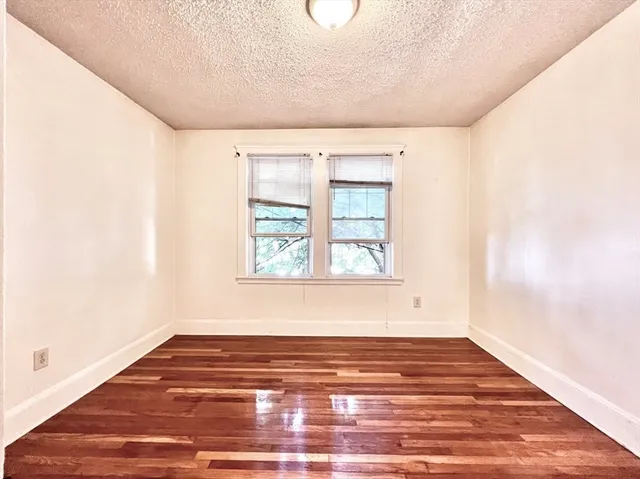 a view of a room with wooden floor and window