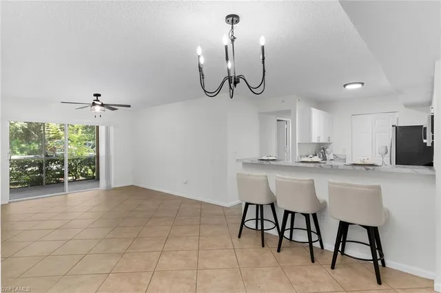 a kitchen with stainless steel appliances a table chairs and entryway