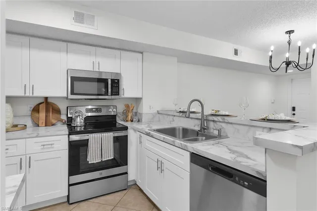 a kitchen with white cabinets and appliances