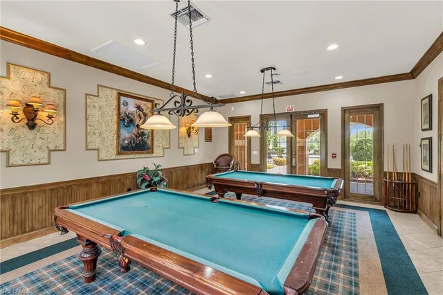 a room with pool table table and windows
