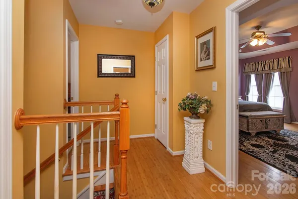 a view of a hallway with entryway and wooden floor
