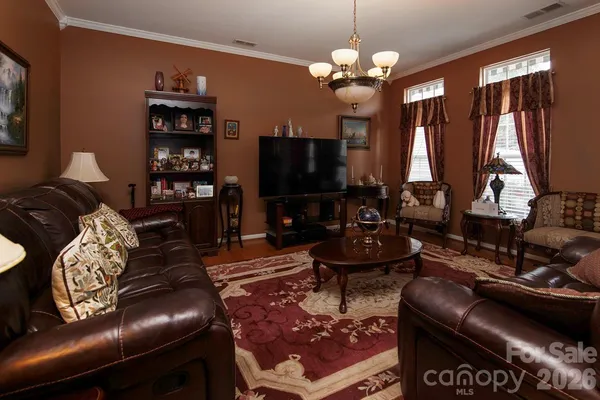 a living room with furniture a flat screen tv and a large window