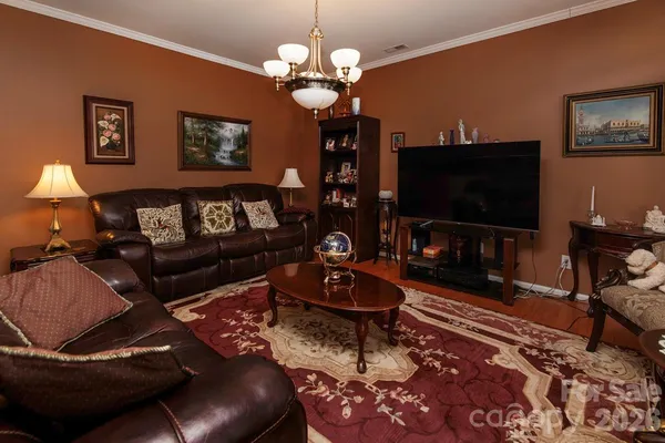 a living room with furniture a flat screen tv and a bookshelf