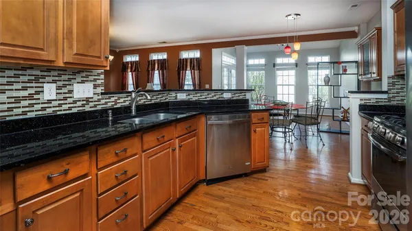 a kitchen with stainless steel appliances granite countertop a stove a sink and a microwave