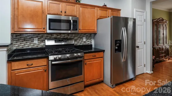 a kitchen with granite countertop a refrigerator stove and microwave
