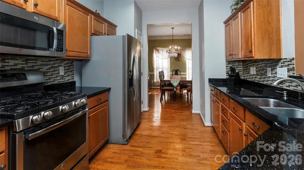 a kitchen with stainless steel appliances granite countertop a stove and a refrigerator