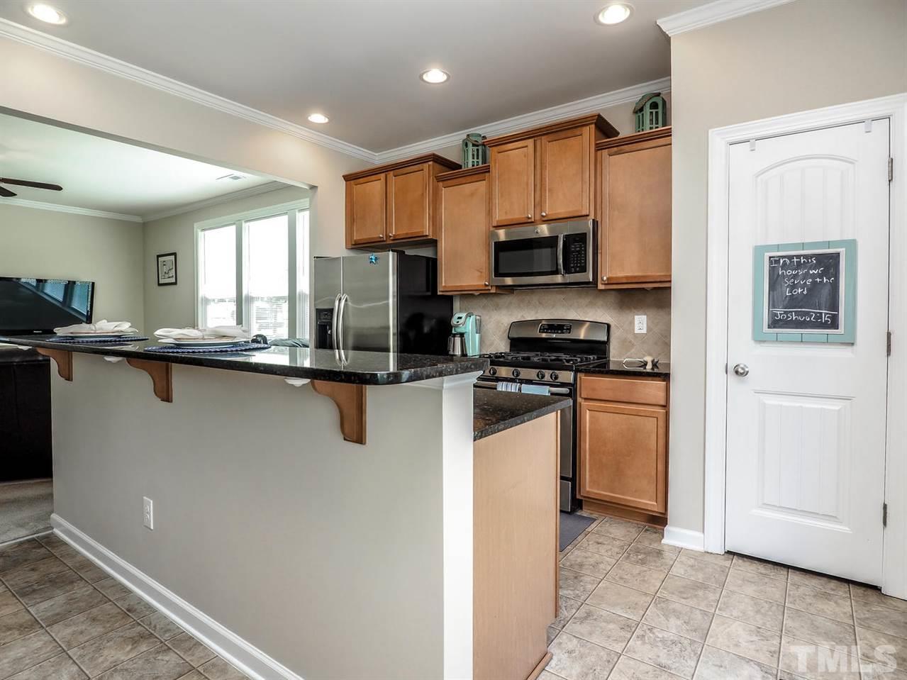 1105 Falcon Ridge Lane Morrisville, NC 27560 - Photo 11 of 22 a kitchen with stainless steel appliances granite countertop a refrigerator a sink a stove top oven and a refrigerator
