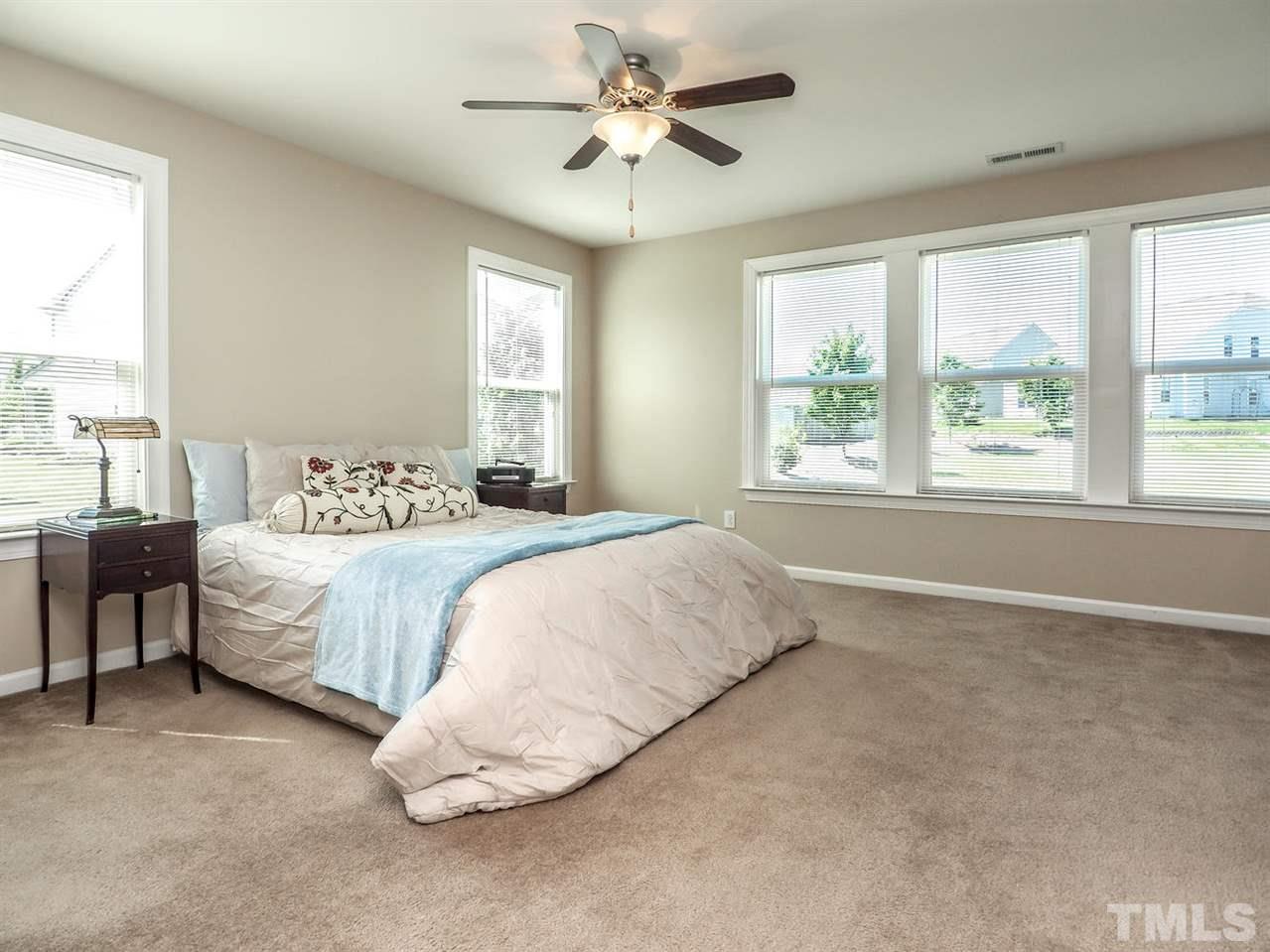 1105 Falcon Ridge Lane Morrisville, NC 27560 - Photo 19 of 22 a spacious bedroom with a bed and a chandelier