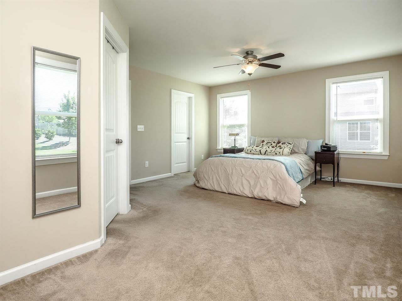 1105 Falcon Ridge Lane Morrisville, NC 27560 - Photo 20 of 22 a bedroom with a large bed and a chandelier