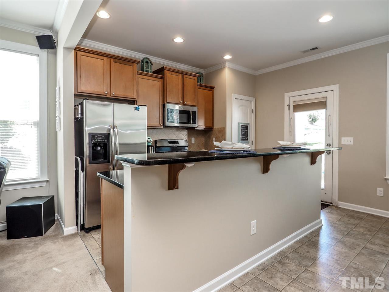 1105 Falcon Ridge Lane Morrisville, NC 27560 - Photo 10 of 22 a kitchen with stainless steel appliances granite countertop a refrigerator a stove and a sink with wooden floor