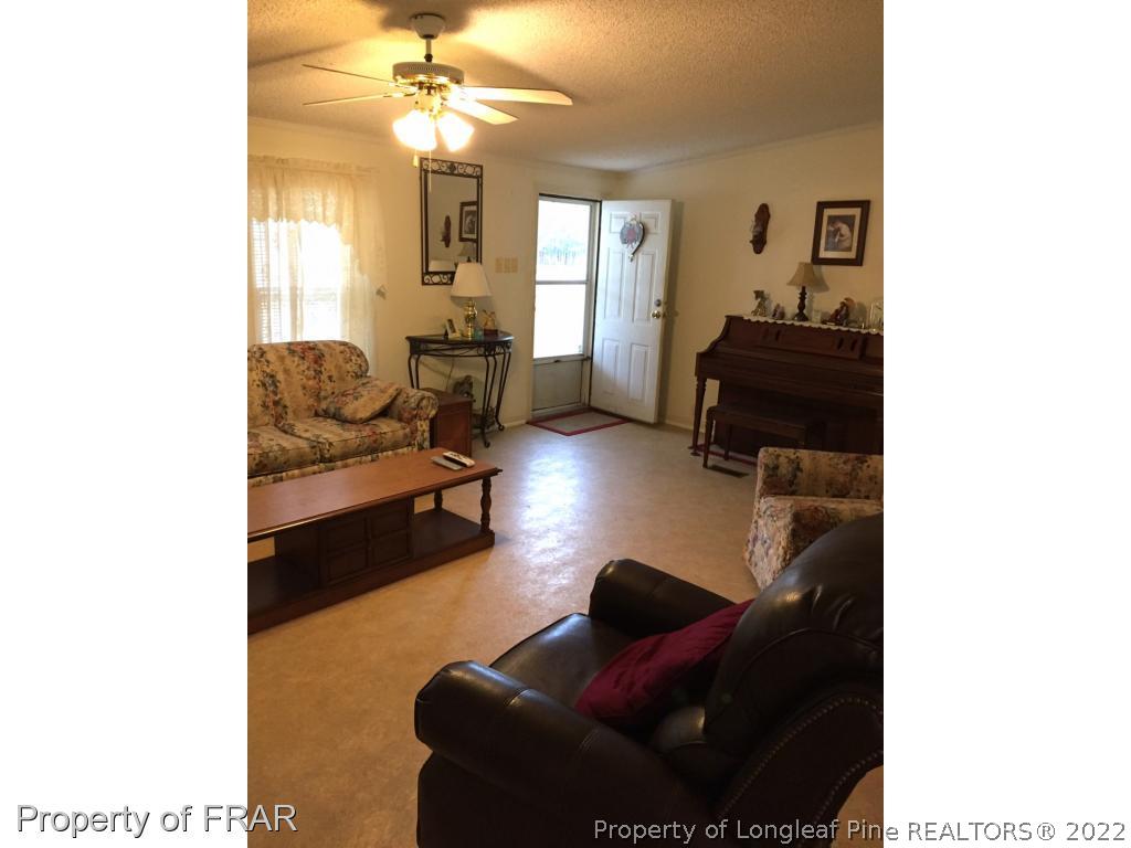 2311 Calloway Road Raeford, NC 28376 - Photo 2 of 13 a living room with furniture and a chandelier