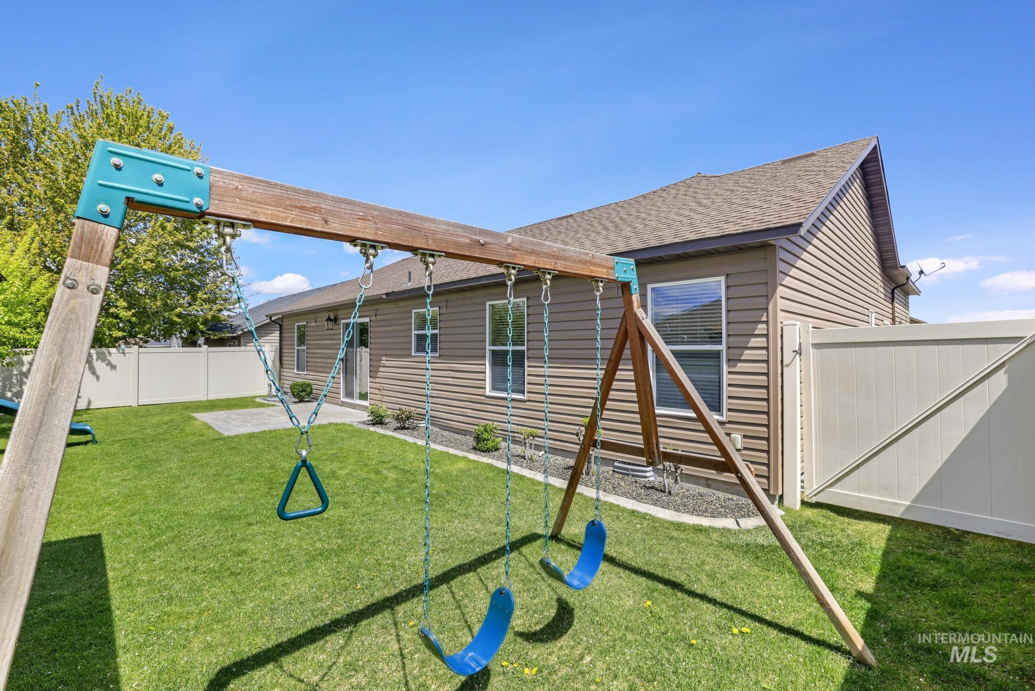 446 Noble Street Twin Falls, ID 83301 - Photo 27 of 42 Expansive backyard featuring a lush lawn, privacy fencing, and a built-in patio area