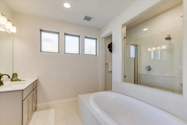 a bathroom with a double vanity sink mirror and bathtub