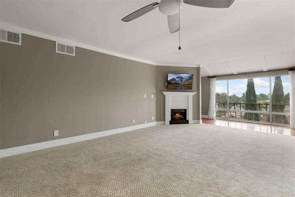 12830 Burbank Boulevard, Unit 316 Valley Village, CA 91607 - Photo 4 of 18 a view of an empty room with a fireplace and a large window