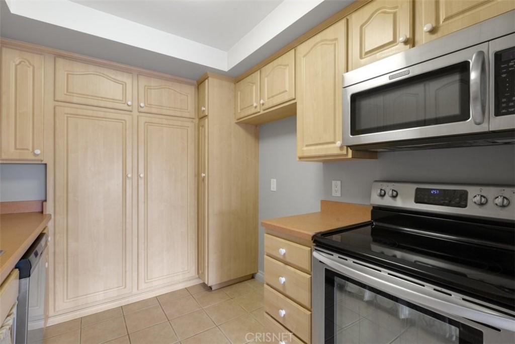 12830 Burbank Boulevard, Unit 316 Valley Village, CA 91607 - Photo 6 of 18 a kitchen with stainless steel appliances a stove a microwave and cabinets