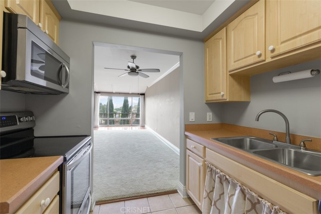 12830 Burbank Boulevard, Unit 316 Valley Village, CA 91607 - Photo 7 of 18 a kitchen with stainless steel appliances granite countertop a sink and a stove