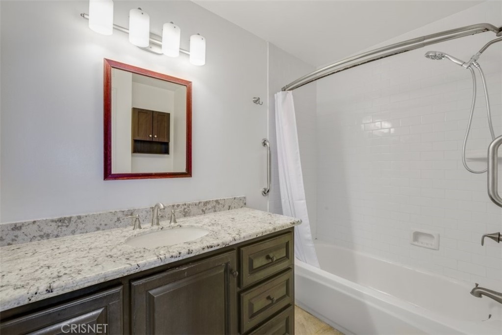 12830 Burbank Boulevard, Unit 316 Valley Village, CA 91607 - Photo 9 of 18 a bathroom with a granite countertop sink mirror vanity and bathtub