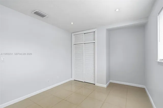 an empty room with windows and closet