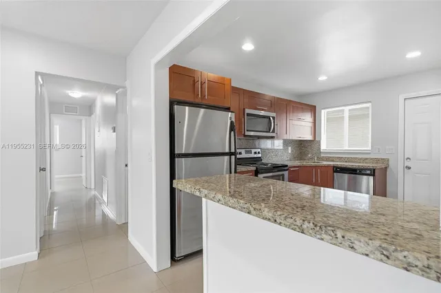 a kitchen with stainless steel appliances granite countertop a refrigerator and a sink