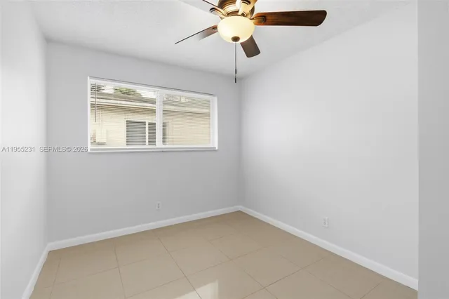 an empty room with a window and a fan