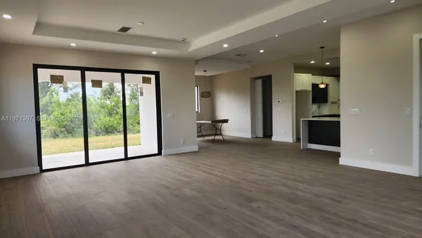 a view of empty room with wooden floor and balcony