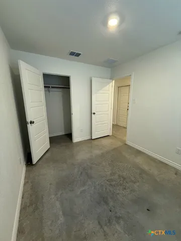 an empty room with closet and windows