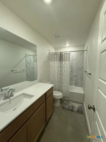 a bathroom with a granite countertop sink a toilet and shower