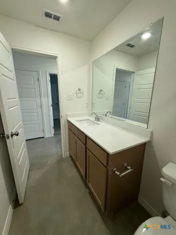 a bathroom with a sink toilet and mirror
