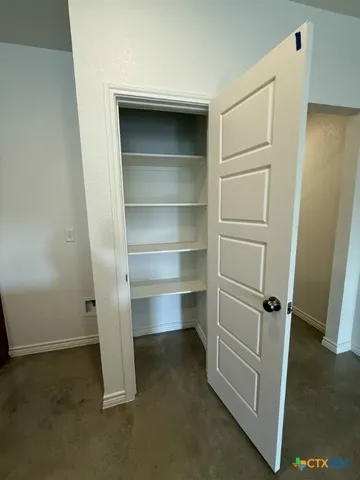 a view of walk in closet with empty racks