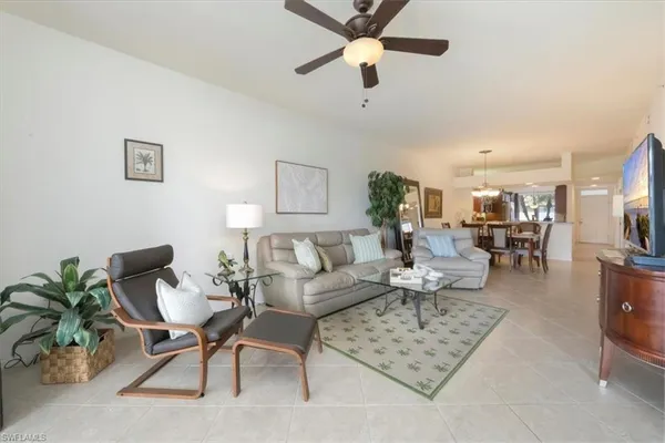 a living room with furniture and a view of kitchen