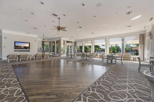 a very nice looking living room with a large window a couch and chandelier