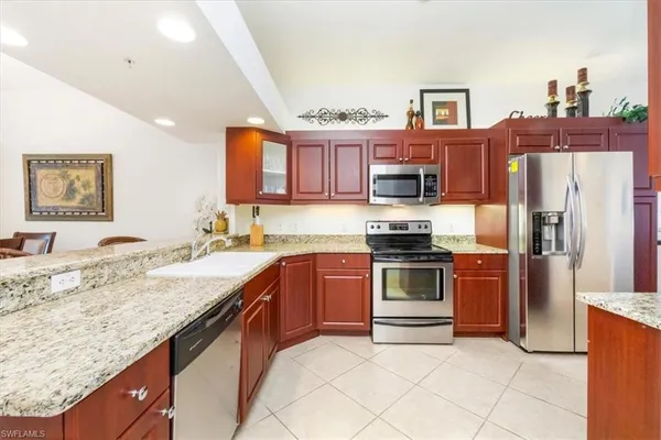 a kitchen with stainless steel appliances granite countertop a stove top oven a sink and dishwasher
