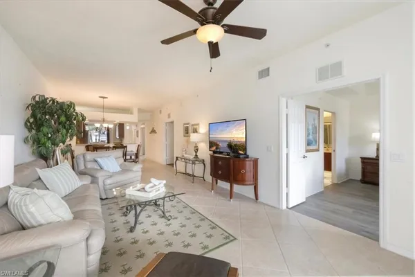 a living room with furniture a chandelier and a flat screen tv