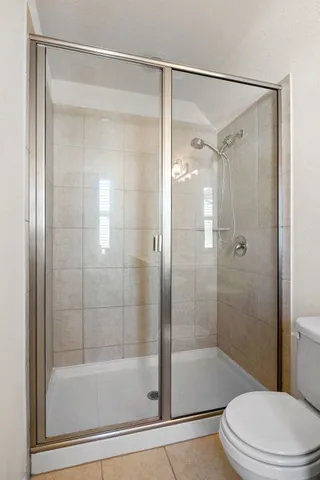 a bathroom with a shower a toilet and a shower