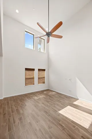 a view of an empty room with a window and wooden floor