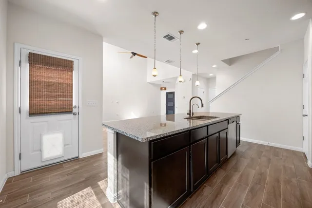 a kitchen with a sink a counter space and wooden floor