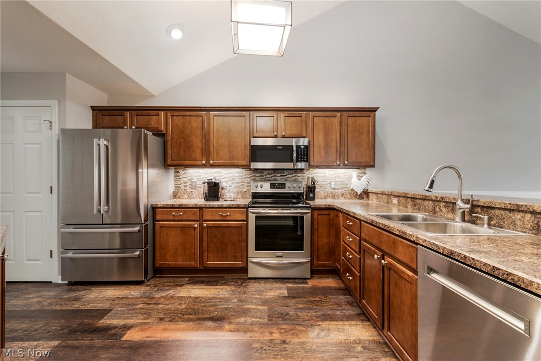 9151 Springfield Road, Unit 1902 Youngstown, OH 44514 - Photo 14 of 36 Kitchen with dark hardwood / wood-style flooring, backsplash, high vaulted ceiling, sink, and appliances with stainless steel finishes