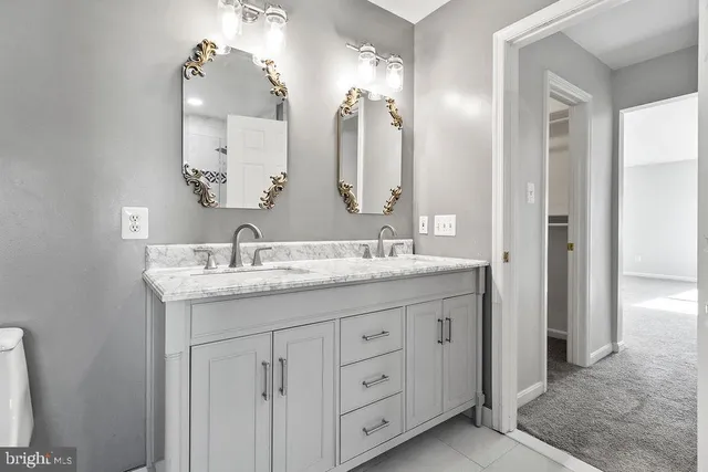 a bathroom with a granite countertop sink double and a mirror