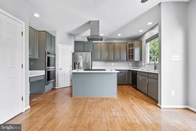 a large kitchen with stainless steel appliances sink a microwave and cabinets