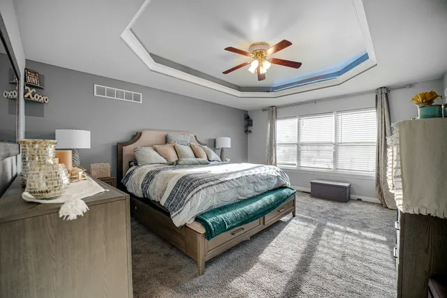 a spacious bedroom with a bed and a chandelier
