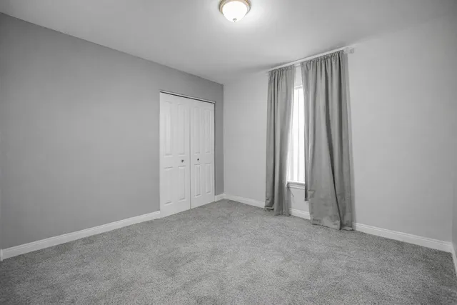an empty room with closet and mirror