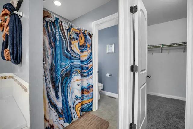 a view of walk in closet with clothes and shoes