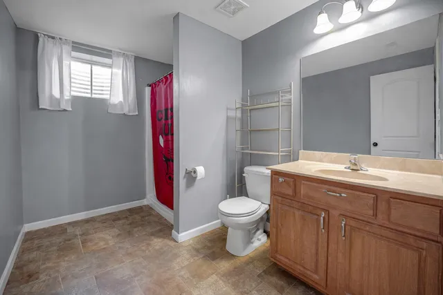 a bathroom with a sink vanity mirror and toilet