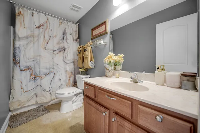 a bathroom with a granite countertop sink mirror vanity and toilet