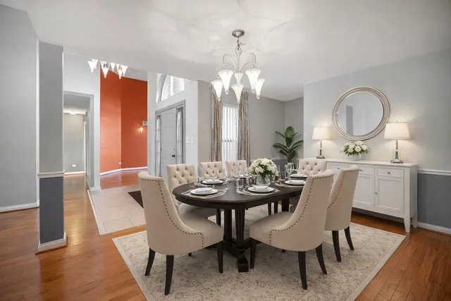 a dining room with furniture a chandelier and wooden floor
