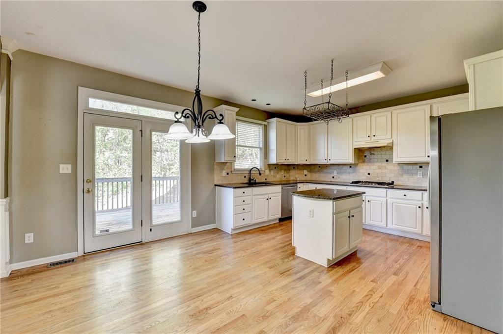 3407 Highland Forge Trail Dacula, GA 30019 - Photo 11 of 71 a kitchen with stainless steel appliances granite countertop a refrigerator a sink dishwasher a stove and white countertops with wooden floor
