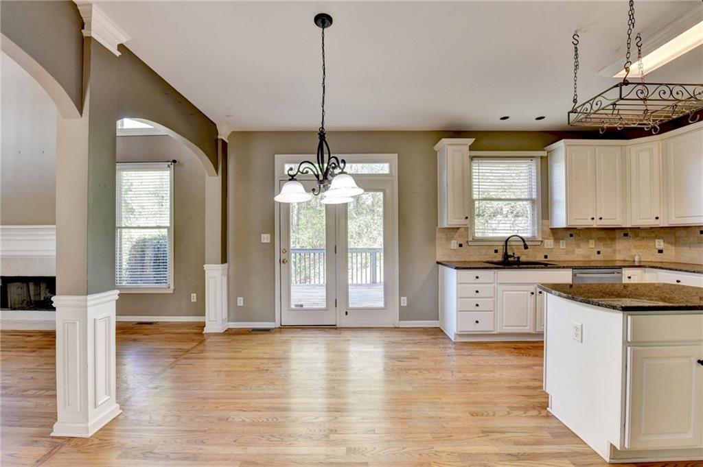 3407 Highland Forge Trail Dacula, GA 30019 - Photo 12 of 71 a large kitchen with cabinets wooden floor and a chandelier