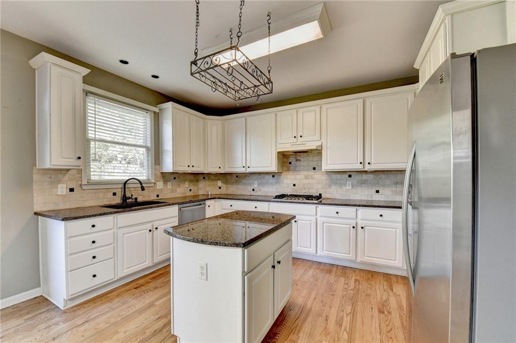 3407 Highland Forge Trail Dacula, GA 30019 - Photo 13 of 71 a kitchen with granite countertop a sink cabinets stainless steel appliances and a window