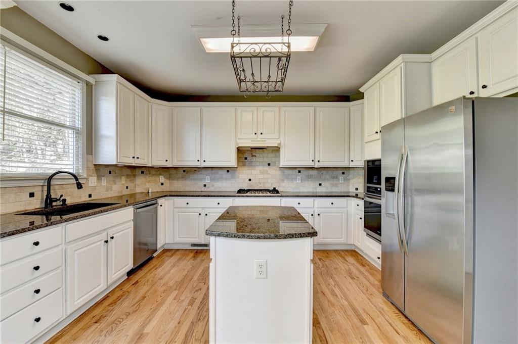 3407 Highland Forge Trail Dacula, GA 30019 - Photo 14 of 71 a kitchen with granite countertop a sink stainless steel appliances and window